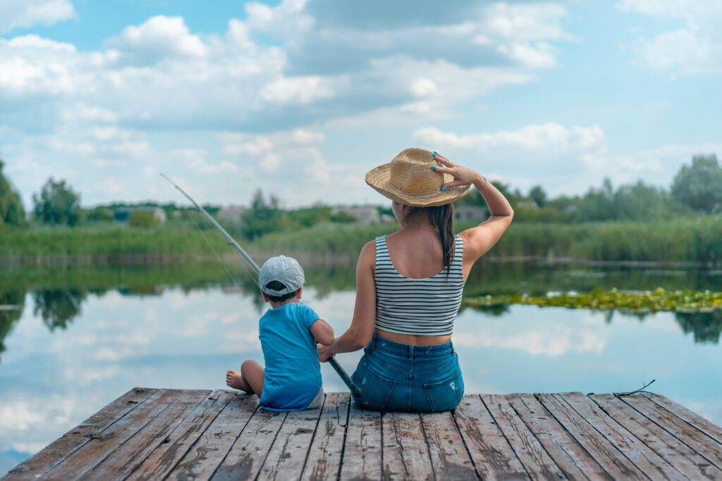 Två personer sitter på en brygga och fiskar
